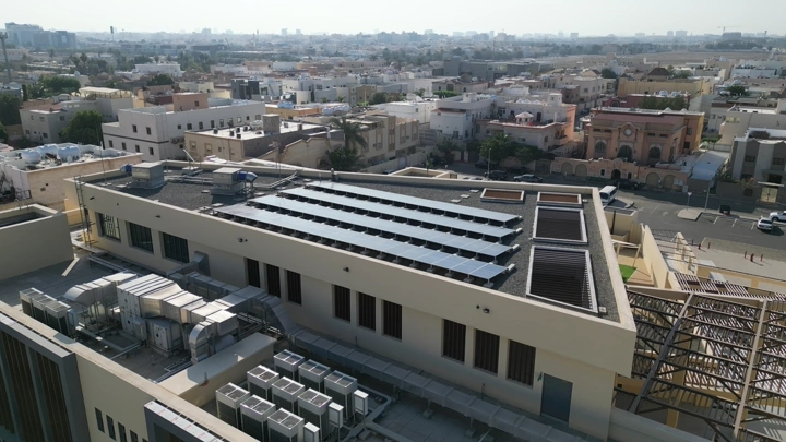 مبنى حديث مع ألواح شمسية على السطح، لقطة جوية نهارية.