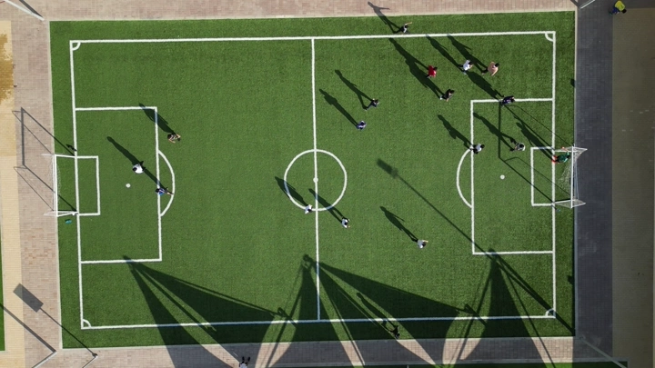 ملعب كرة قدم مع لاعبين من الأعلى، لقطة جوية.