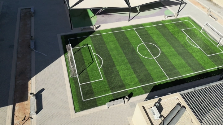 ملعب كرة قدم في مدرسة، لقطة جوية في وضح النهار.