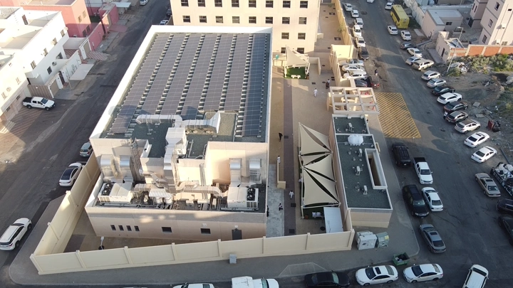 مبنى حديث مع ألواح شمسية على السطح، لقطة جوية.