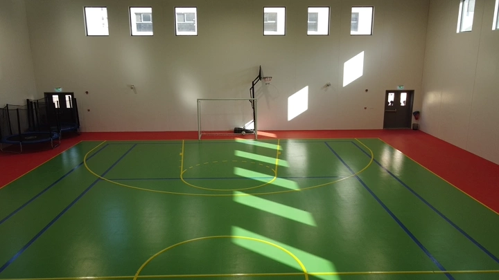 ملعب كرة داخلي مضاء بأشعة الشمس، لقطة من زاوية مرتفعة.