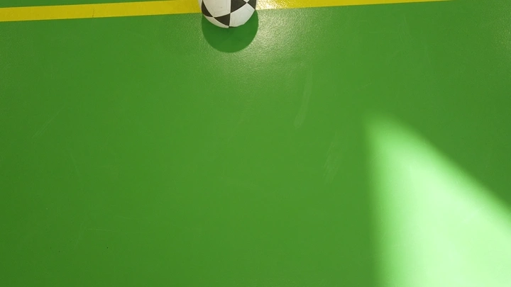 كرة على أرضية ملعب داخلي، لقطة علوية.