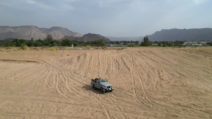 سيارة سفاري مع أطفال في الصحراء، لقطة جوية.