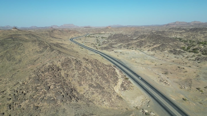 طريق سريع يمر عبر تضاريس صحراوية، لقطة جوية.