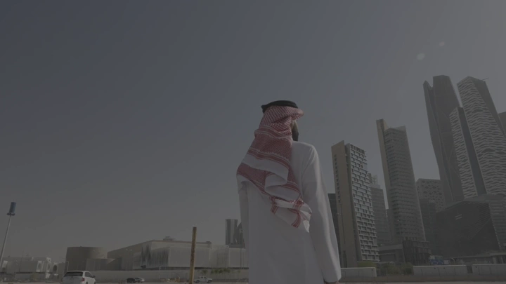 رجل ينظر إلى أبراج كافد في الرياض، لقطة من الخلف.