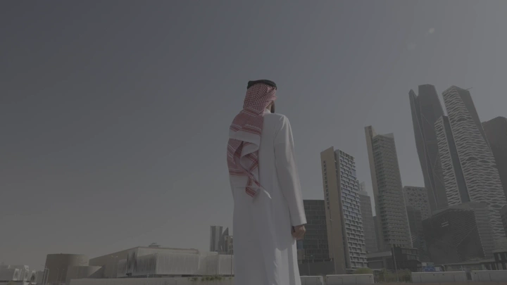 رجل ينظر إلى أبراج كافد في الرياض، لقطة من الخلف.