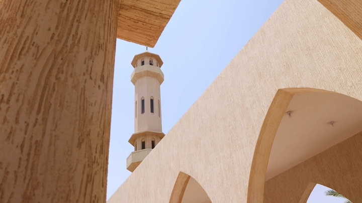 مئذنة مسجد تحت سماء زرقاء، لقطة بزاوية منخفضة.