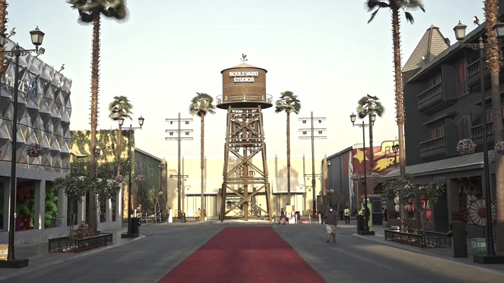 شارع في البوليفارد الرياض مع برج مياه في المنتصف، لقطة نهارية.