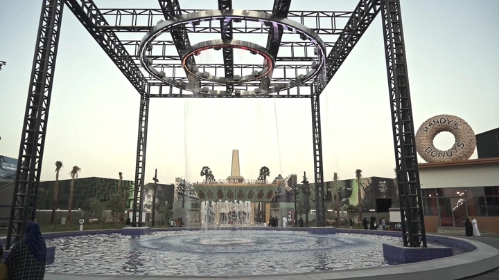 نافورة دائرية في البوليفارد الرياض عند الغروب، لقطة واسعة.