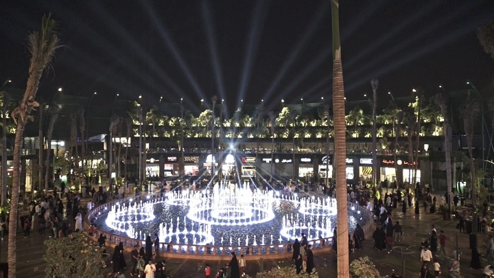 نافورة مضيئة في البوليفارد الرياض ليلاً، لقطة علوية.