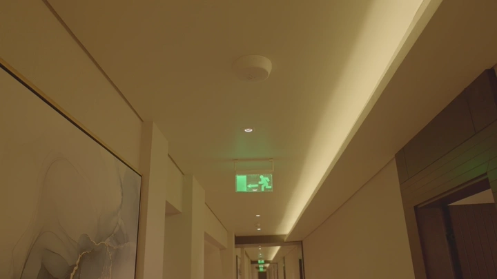 ممر مضاء في فندق مع لوحة خروج مضيئة، زاوية منخفضة.