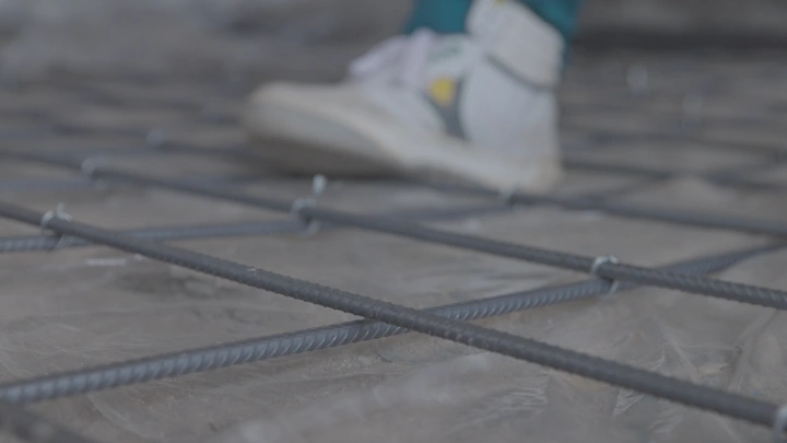 شبكة حديدية على الأرض مع حذاء رياضي، لقطة قريبة.