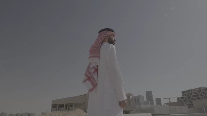 رجل ينظر إلى المدينة المالية في الرياض، لقطة جانبية.