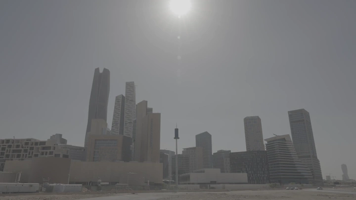 شخص يتأمل  المدينة المالية بالرياض تحت الشمس ، لقطة نهارية.