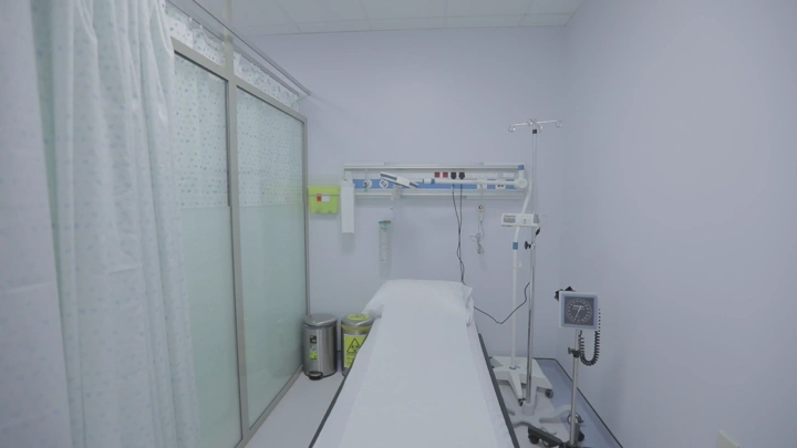 سرير مستشفى في غرفة بيضاء، لقطة داخلية.