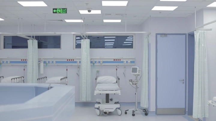 غرفة مستشفى حديثة مع أسرة وأجهزة طبية، لقطة داخلية.