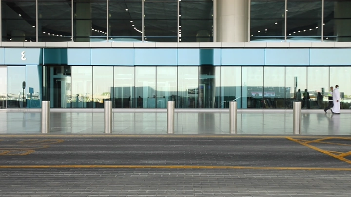 واجهة مطار حديثة مع انعكاسات على الزجاج، لقطة أمامية.