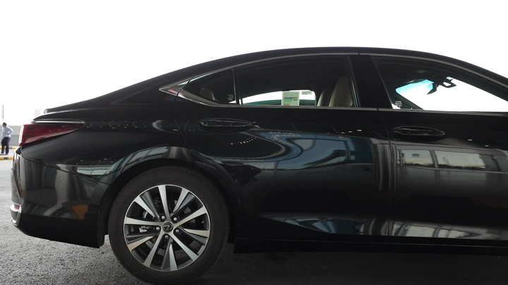 سيارة سوداء متوقفة في موقف سيارات، لقطة جانبية.