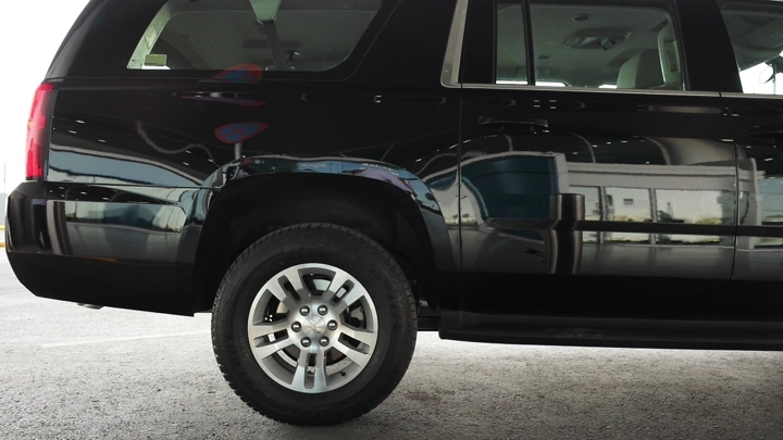 رجل يركب سيارة سوداء في المطار، لقطة جانبية.