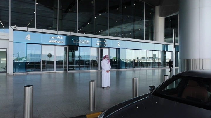 رجل يركب سيارة من عند المطار، لقطة نهارية.