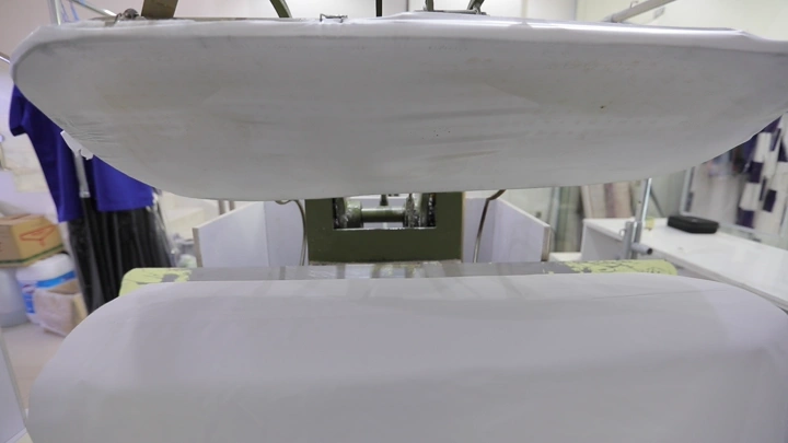 آلة كي الملابس في مغسلة، لقطة من الأمام.