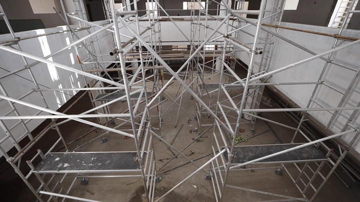 سقالات معدنية في موقع بناء داخلي، لقطة من الأعلى.