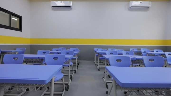 فصل دراسي حديث بمقاعد زرقاء، لقطة داخلية.