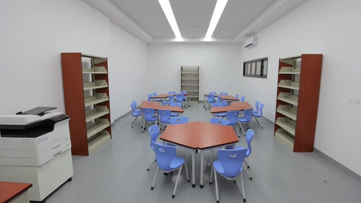 فصل دراسي حديث مع طاولات وكراسي زرقاء، لقطة داخلية.