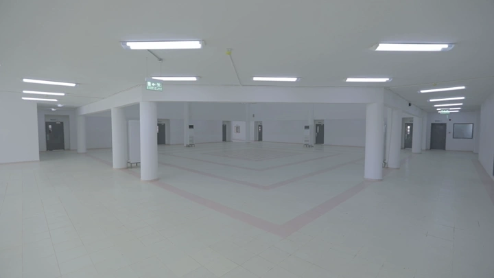 ردهة مدرسة واسعة بإضاءة ساطعة، لقطة داخلية.