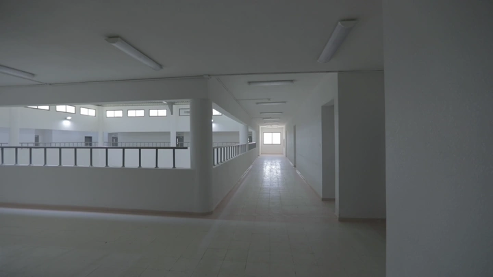 ممر مدرسة حديثة من الداخل، إضاءة طبيعية، لقطة واسعة.