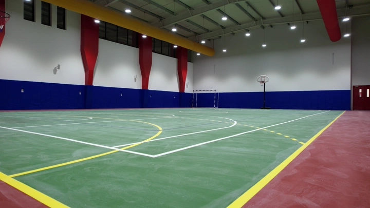 ملعب كرة داخلي حديث بإضاءة ساطعة، زاوية واسعة.