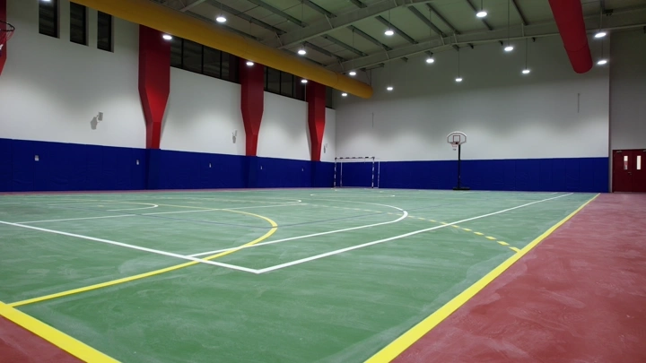 ملعب كرة داخلي فارغ بإضاءة ساطعة، لقطة بزاوية واسعة.