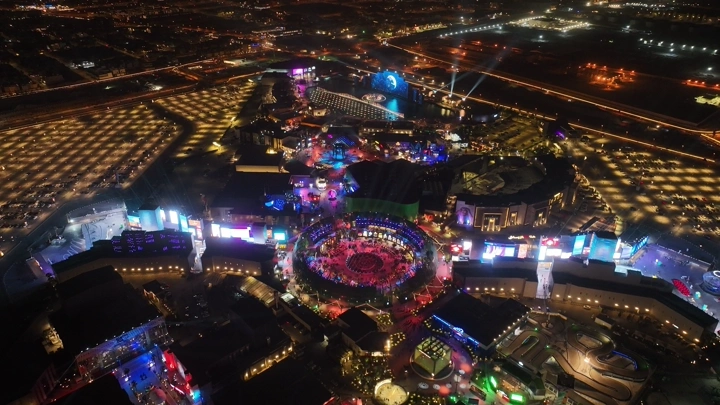 منظر جوي للبوليفارد في الرياض ليلاً، مليء بالأضواء الملونة.