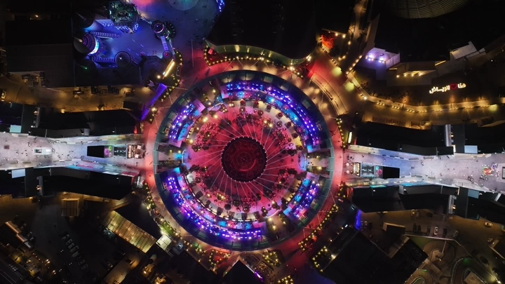 لقطة جوية للبوليفارد في الرياض ليلاً بأضواء ملونة.