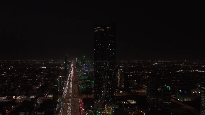 أبراج الرياض ليلاً مع العلم السعودي مضاء، لقطة جوية.