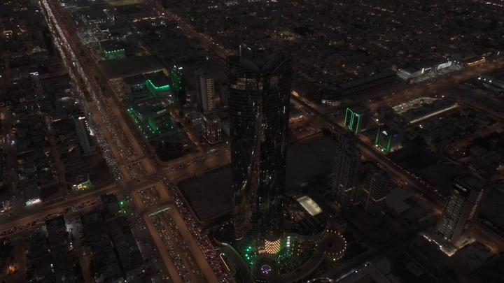 أبراج الرياض مضاءة ليلاً بالأخضر، لقطة جوية.