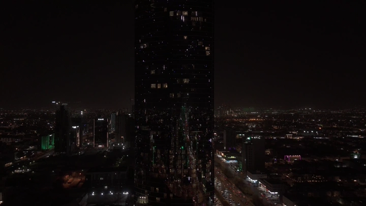 أبراج الرياض ليلاً مع إضاءة العلم السعودي، لقطة جوية.