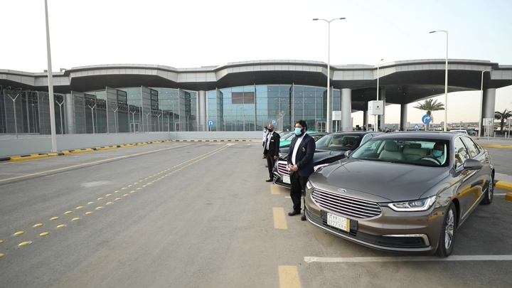 سيارات للتأجير متوقفة أمام مطار الرياض، لقطة نهارية.