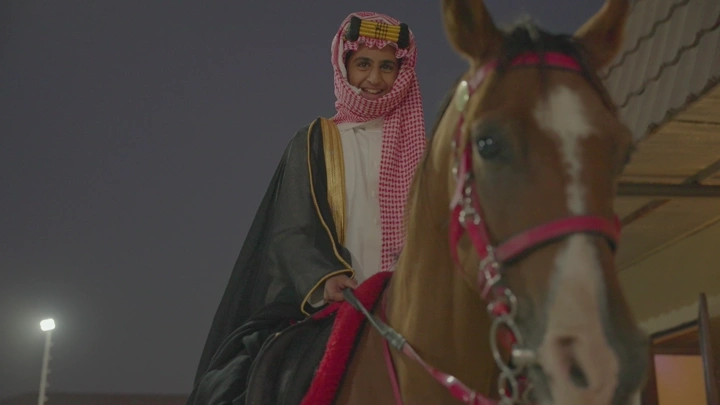 راكب خيل يرتدي الزي التقليدي في الليل، لقطة قريبة.