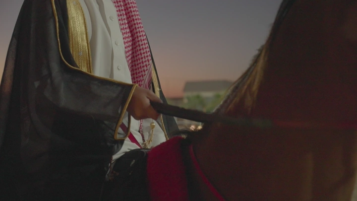 راكب خيل يرتدي زي تقليدي عند الغروب، لقطة قريبة.