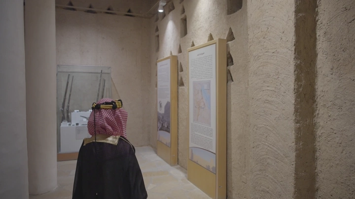 شاب يرتدي الزي السعودي داخل قصر المصمك بالرياض، لقطة داخلية.