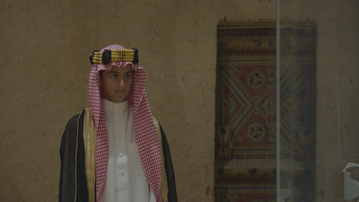 شاب يرتدي الزي السعودي في قصر المصمك بالرياض، لقطة داخلية.