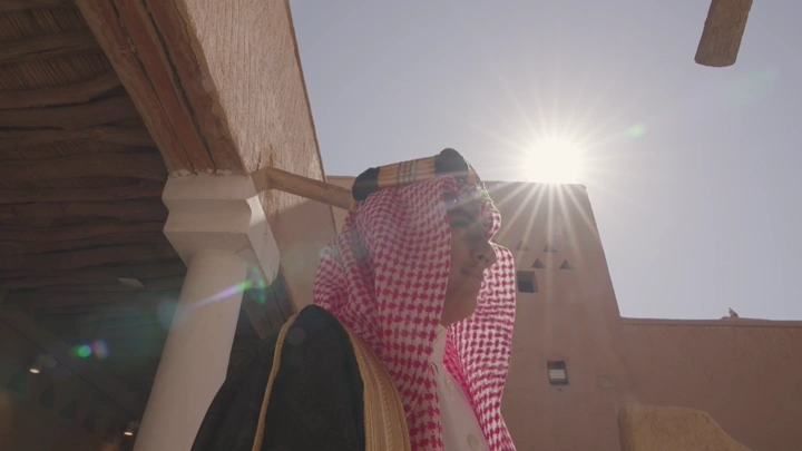 رجل يرتدي الزي السعودي أمام قصر المصمك في الرياض، لقطة نهارية.