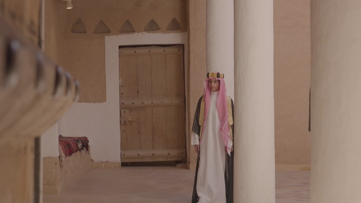 رجل يرتدي الزي السعودي يتجول في قصر المصمك بالرياض، لقطة داخلية.