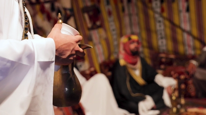 رجال بلباس تقليدي سعودي في خيمة، لقطة داخلية.