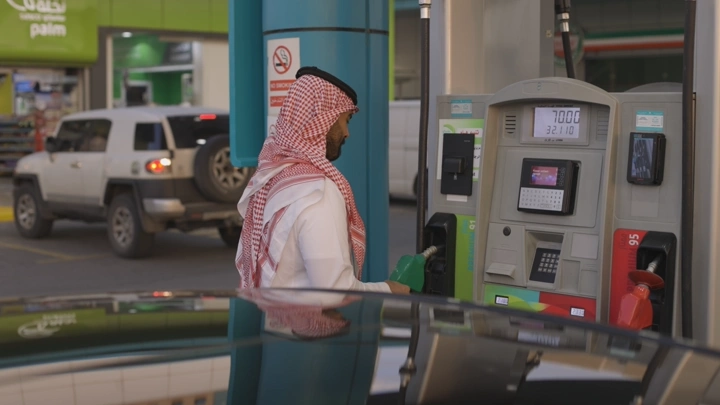 رجل يعبئ وقود في محطة بنزين، لقطة جانبية.