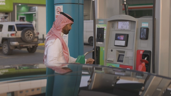رجل يعبئ البنزين في محطة وقود، لقطة نهارية.