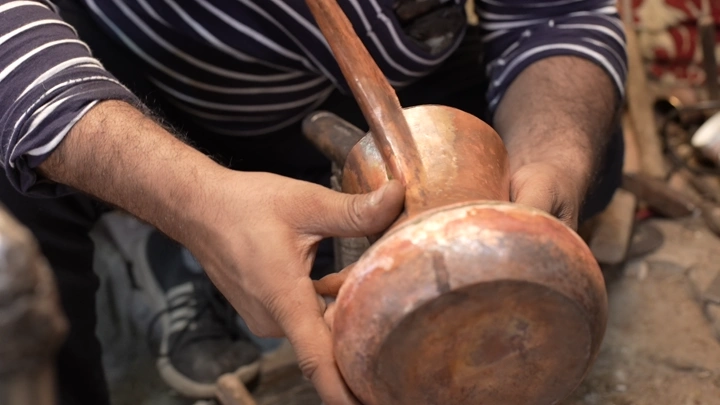 حرفي يصنع دلة في ورشة، لقطة مقربة.