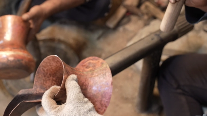 صناعة الدلة النحاسية يدويًا في ورشة، لقطة مقربة.