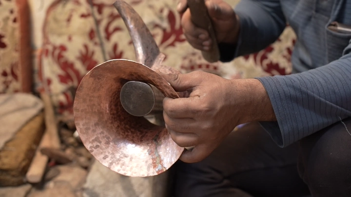 حرفي يصنع دلة نحاسية يدويًا، لقطة مقربة.